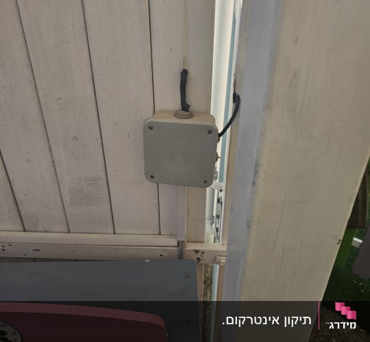 קופסת חיבורים עם כבל מחובר לקיר עץ